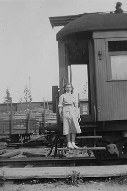 valkoesiliinainen nainen junan portailla